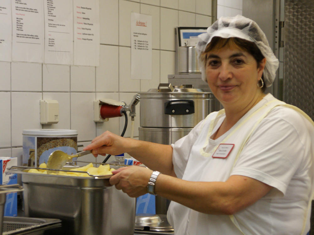 Mitarbeiterin in der Küche beim Kartoffeln kochen